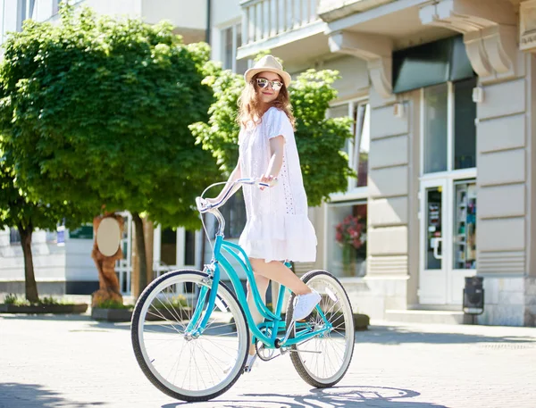 드레스 선글라스와 모자는 도시에서 자전거를 즐기는 여자의 초상화 — 스톡 사진