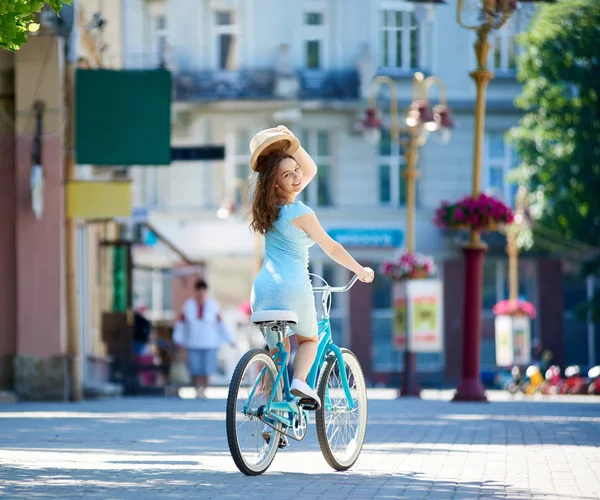 Приваблива Жінка Тримає Капелюх Знак Привітання Катаючись Синьому Вінтажному Велосипеді — стокове фото
