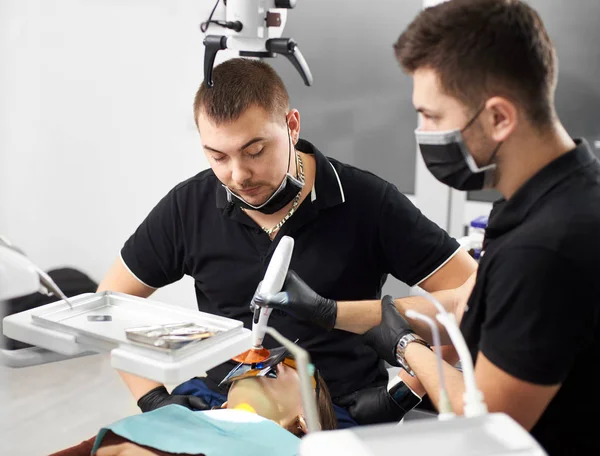 Estomatologista Olha Para Paciente Enquanto Seu Assistente Está Completando Processo — Fotografia de Stock