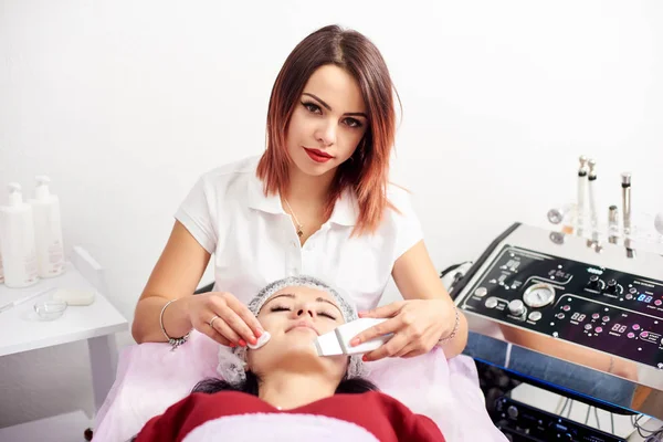 Женщина-косметолог делает ультразвуковой пилинг лица пациентке салона красоты . — стоковое фото