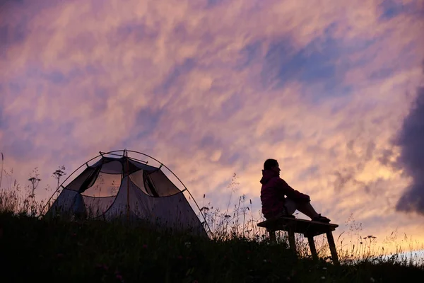 Feminino turista jiker sentado perto de sua tenda no topo da montanha relaxante desfrutando de paisagem deslumbrante no pôr do sol copyspace camping acampamento ativo estilo de vida recreação harmonia viajando turismo . — Fotografia de Stock