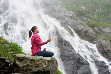 Kadın yogini. Çekici kadın rock güzel Balea şelale Romanya'da yakınındaki Yoga pratik. Kadın turist cazibe cennet şaşırtıcı doğa nefes kesen sahne sakinlik zevk mutluluk