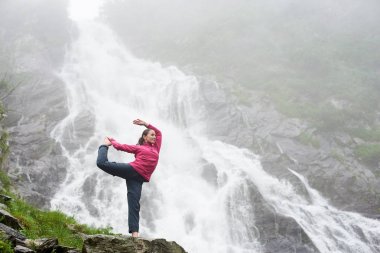 Balea Fagarash Dağları'nda bir şelale altında poz sportif kız. Kayalık şelale dağlarda. Karpatlar Romanya yer.