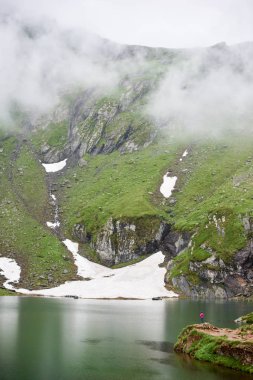 Yüce Dağları sis ve gölün dibinde, Transilvanya, Romanya ile kaplıdır. Küçük kadın figürü görkemli sahne sahiptir