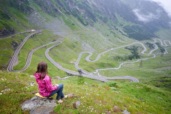 La mujer se sienta en una piedra disfrutando de maravillosos paisajes de montaña. Carretera Transfagarashan, la carretera más hermosa de Europa, Rumania Transfagash, Ridge Fagaras —  Fotos de Stock