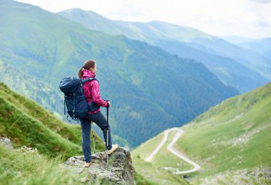 Sırt çantasıyla turizm yaşam tarzı anılar uyum yerler etkin hiking kadın yolcu uzağa Romanya seyahat Transfagarasan Road'da arıyorsunuz bir tepe üstünde dinlenme sırt çantası ile.