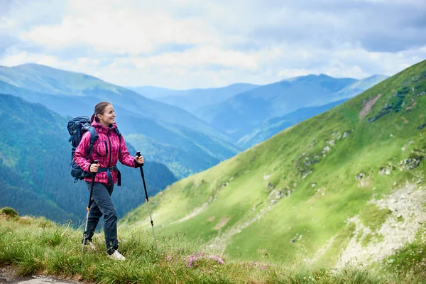 Młoda kobieta z plecaka i trekking kije turystyczne w górach Rumunii. Pojęcie zdrowego i aktywnego stylu życia. Dziewczyna na tle przyrody z potężnych szczytów — Zdjęcie stockowe