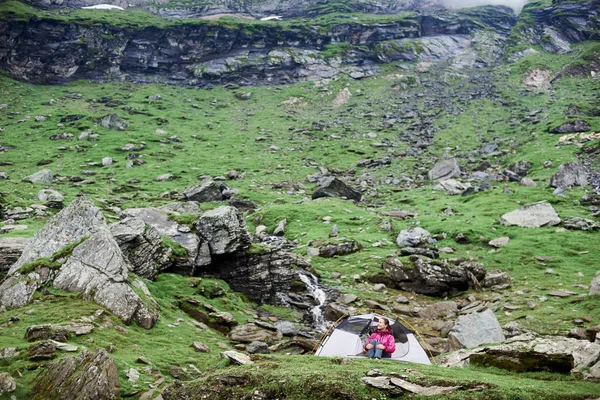 Turysta kobieta siedzi w pobliżu jej relaing namiot w górach po turystyka tło rekreacja hobby, Podróże Turystyka aktywna życia styl życia przyrody ekologia środowiska wildersness. — Zdjęcie stockowe