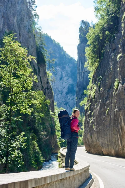 Fata fericită stă pe un drum de munte din munții Carpați din România. Peisajul de vară al faimoaselor Cheile Bicazului din județul Neamț, România . — Fotografie, imagine de stoc