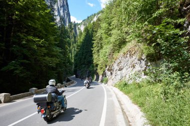 Turistler bisikletçileri arasında yüksek dikey kayalık uçurum Bicaz Kanyon, Romanya'da dağ yolda motosikletler içinde seyahat. Bir Romanya'da en muhteşem yolların. Macera ve seyahat Tema.