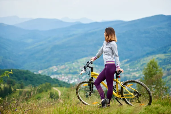 Jonge vrouwelijke fietser permanent — Stockfoto