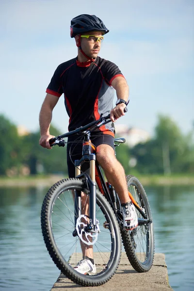Jovem Motociclista Roupas Ciclismo Profissional Capacete Posando Perto Bicicleta Olhando — Fotografia de Stock