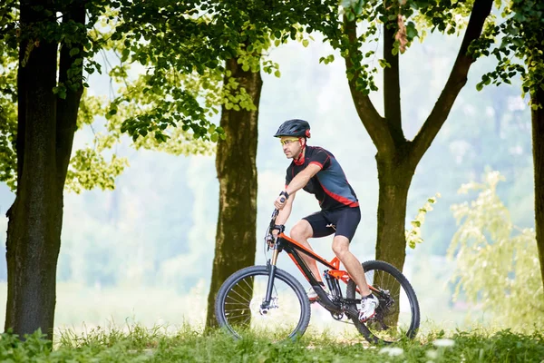 Mannelijke Biker Sportkleding Beschermende Helm Rijden Fiets Door Zonnige Park — Stockfoto