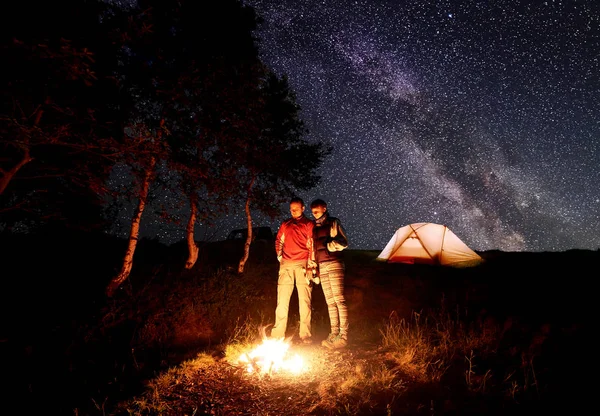 Young Couple Hikers Standing Campfire Beer Hands Orange Tent Sky — Stock Photo, Image