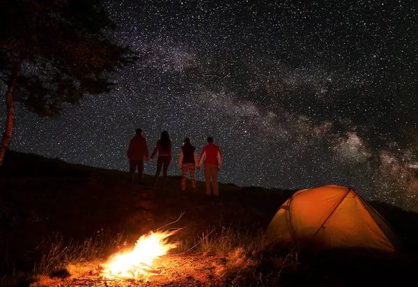 Arkadan Iki Çift Elele Samanyolu Yıldızlı Gökyüzü Bir Kamp Ateşi — Stok fotoğraf