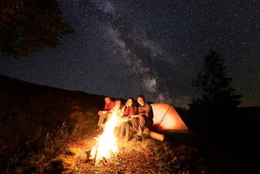 Bir gece yıldızlar ve Samanyolu ile mayınları inanılmaz güzel gökyüzüne karşı dağlarda kamp sırasında bir günlük parlak kamp ateşi yakınındaki bir dinlenme sahip dört mutlu yürüyüşçü. Aktif dinlenme kavramı