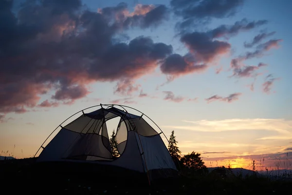 일몰에 텐트는 구름과 야생화와 잔디에 활동적인 생활의 — 스톡 사진