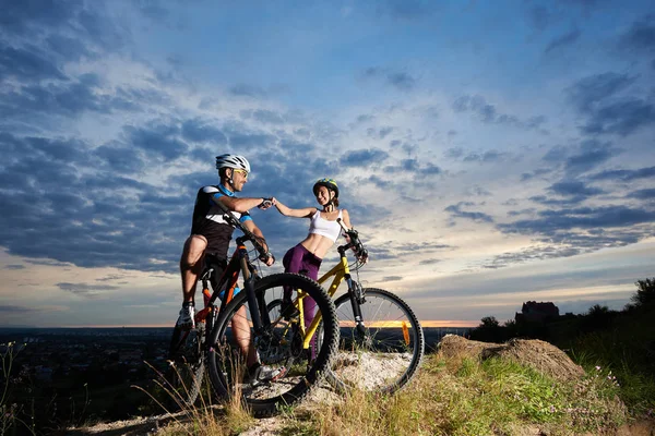 Lächelndes Junges Radlerpaar Mit Helm Auf Mountainbikes — Stockfoto