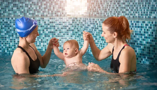 Dvě Ženy Drží Chlapečka Ruce Bazénu Modrém Pozadí Bezpečnostní Plavecké — Stock fotografie