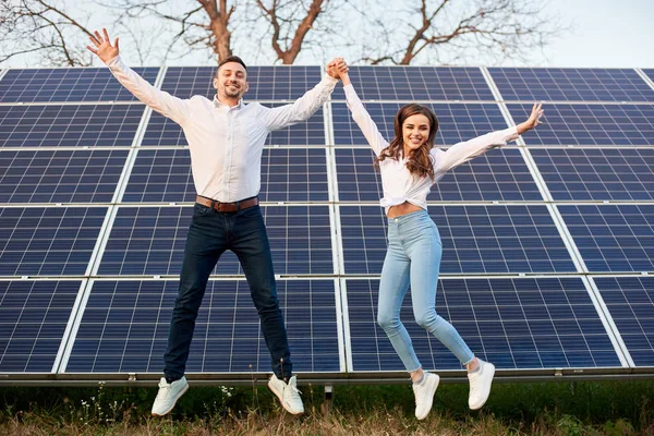 Весела Молода Пара Стрибає Разом Тримаючись Руки Тлі Сонячних Панелей — стокове фото