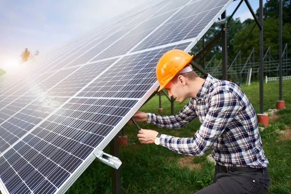 Engineer connecting solar panels on a green plantation. Home construction. Solar station development concept. Construction industry.