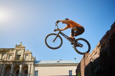 Siyah bir spor bisikletli sporcunun takla attığı görüntüler. Kırmızı tuğlaların üzerinde duran atletli bisiklet. Dinlenme kavramı.