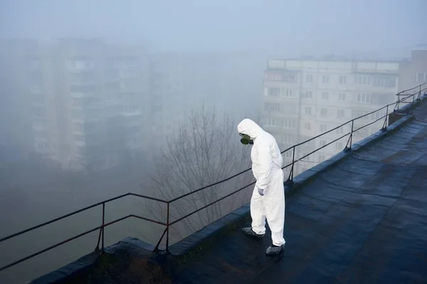 Człowiek Stojący Dachu Bloku Mieszkalnego Naukowiec Noszący Biały Kombinezon Ochronny — Zdjęcie stockowe