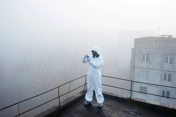 Humano Terno Protetor Segurando Frasco Está Centro Instantâneo Manhã Nebulosa — Fotografia de Stock