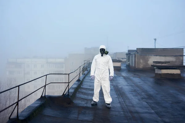 Człowiek Stojący Dachu Bloku Mieszkalnego Noszący Biały Kombinezon Ochronny Maskę — Zdjęcie stockowe