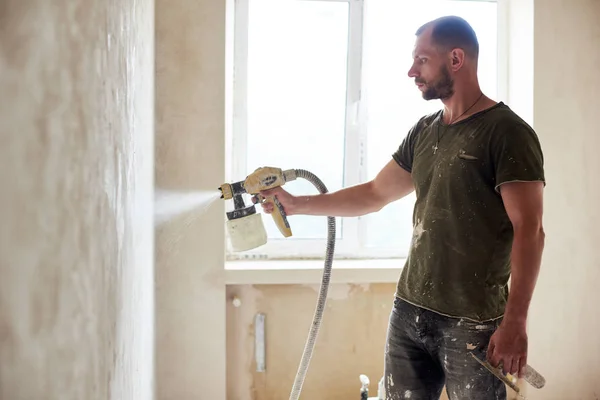 Homem Construtor Está Pintando Com Parede Aerógrafo Reparação Casa Contra — Fotografia de Stock