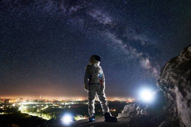 Görev uzmanı astronot Rocky Hill 'de duruyor ve Samanyolu ile güzel yıldızlı gökyüzüne bakıyor. Uzay yolcusu beyaz uzay giysisi ve miğfer giyiyor. İnsan uzay keşfi kavramı.