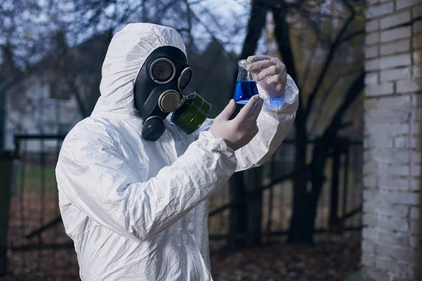 保護服の科学者とガスマスクは 排除ゾーンで作業し 実験室のツールや地元のサンプルを使用してテストを行います — ストック写真