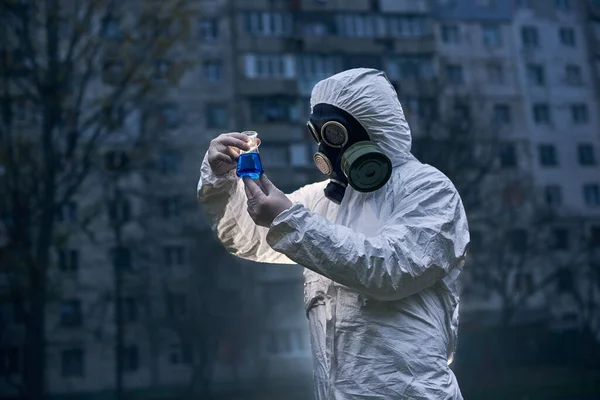 Laboratorní Pracovník Bílé Kombinéze Plynové Masce Skleněnou Baňkou Vzorky Pozorování — Stock fotografie