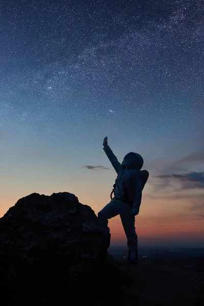 Space Traveler Standing Rocky Mountain Pointing Stars Silhouette Astronaut Wearing — Stock Photo, Image