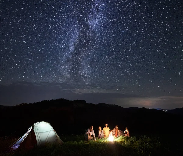 산에서 야영하는 여름에 모닥불 주위에서 휴식을 취하고 관광객들은 은하수가 아름다운 — 스톡 사진