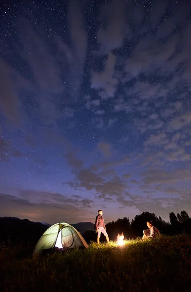 Přátelé Kolem Táboráku Stanu Pozadí Mocných Hor Pod Hvězdnou Oblohou — Stock fotografie