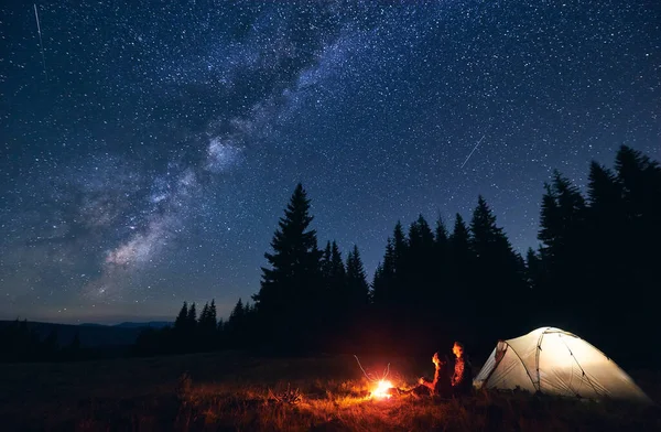Genç Çift Yanan Şenlik Ateşinin Yanında Oturuyor Turist Çadırını Aydınlatıyor — Stok fotoğraf