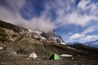 Geceleri mavi bulutlu gökyüzü, parlayan yıldızlar, karlı güzel dağlar. Yüksek kayalık tepeli muhteşem dağ sırtı Matterhorn, iki renkli turist çadırı, harikalar diyarı..
