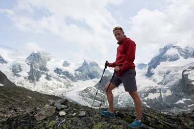Turistler yürüyüş çubuklarıyla yürüyor, kameralara bakıyor, karlı güzel dağlara bakıyor. Dağ yürüyüşü, adam zirveye ulaşıyor. İnanılmaz manzaralı vahşi doğa. Alplerde spor turizmi.