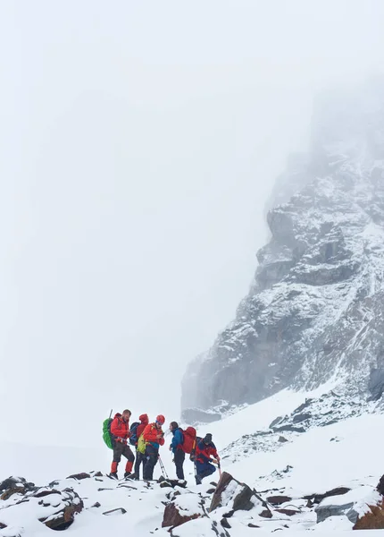 Команда Туристов Стоит Скалистой Тропе Рядом Высокой Горой Покрытой Снегом — стоковое фото