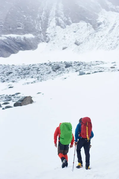 Вид Сзади Самцов Альпинистов Рюкзаком Идущих Снегу Направляющихся Вершине Горы — стоковое фото