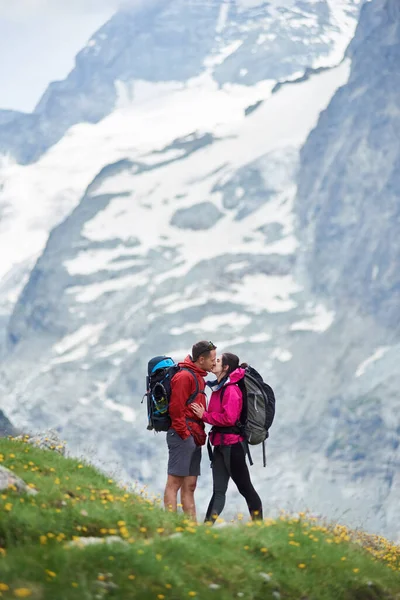 Молодая Пара Туристов Целуется Швейцарских Альпах Стоя Зеленом Лугу Полном — стоковое фото
