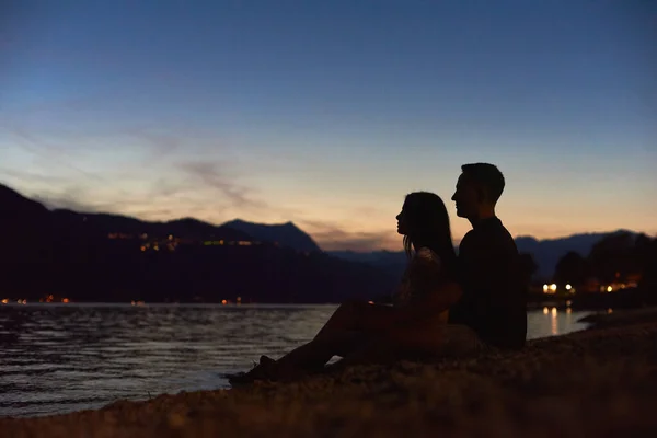 在海滩上欣赏美丽落日的年轻夫妇的侧景轮廓 男朋友和女朋友在海边共度柔情时光 浪漫和关系的概念 — 图库照片