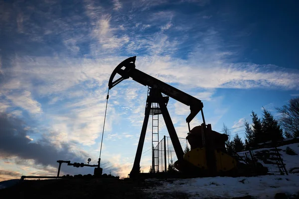 Magnificent view of evening cloudy sky over petroleum pump jack