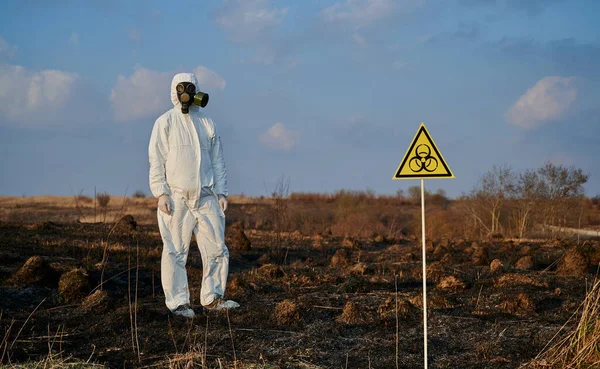 Ekolog Kombinezonie Ochronnym Masce Gazowej Stojący Polu Spalonej Trawie Znakiem — Zdjęcie stockowe