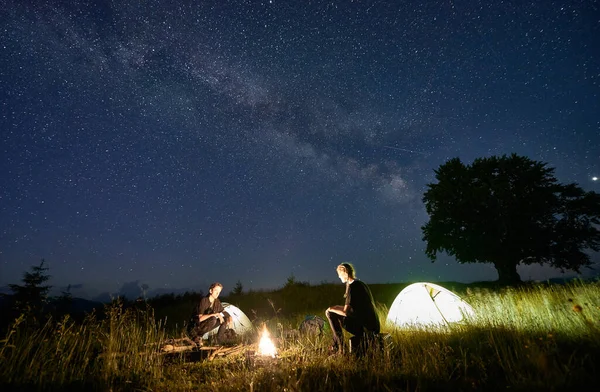 등산객들은 통나무로 벤치에 텐트와 옆에서 구경했다 은하와 하늘의 실루엣 — 스톡 사진
