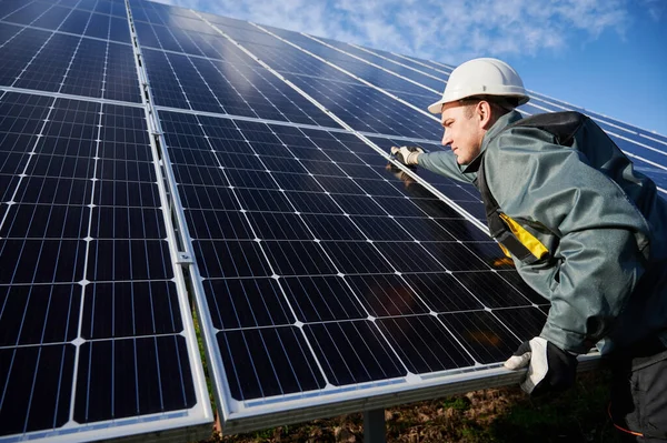 プロの労働者は 保護スーツ ヘルメットと手袋を着用し 晴れた日に太陽電池を設置します 代替エネルギーと電力の持続可能な資源の概念 — ストック写真