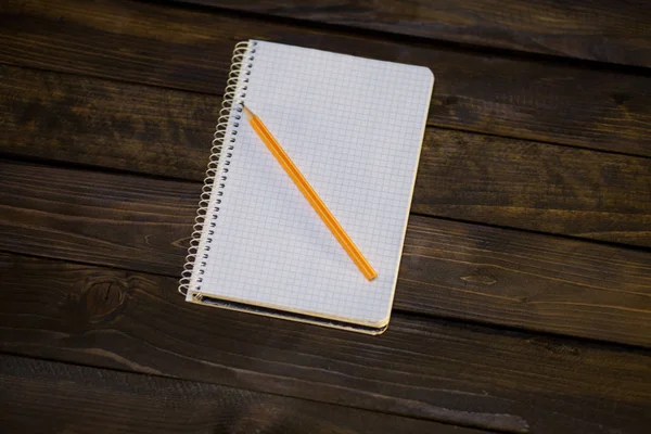 Notebook in a cage and yellow pencil — Stock Photo, Image