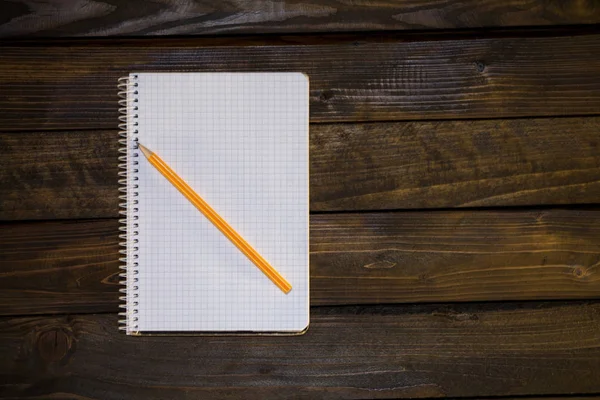 Carnet dans une cage et crayon jaune — Photo