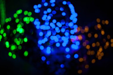 Soyut siyah arka plan üzerinde renkli yeşil, mavi, kırmızı bokeh